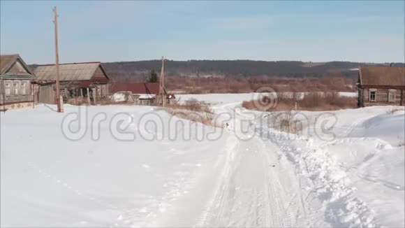 冬天的俄罗斯公路村内冬季道路村庄的冬季景观从一架四翼飞机上拍摄下来视频的预览图