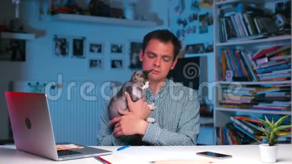 商人坐在桌边抱着一只猫在怀里视频的预览图