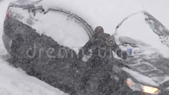 人们在清理汽车挡风玻璃上的冰雪时动作缓慢视频的预览图