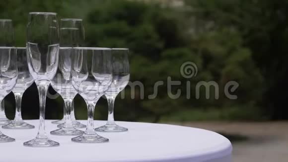桌子上排列着各种玻璃杯的移动镜头等待着装满饮料视频的预览图
