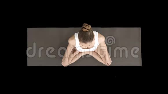 年轻运动女性练习瑜伽坐在莲花姿势和深呼吸阿尔法频道视频的预览图