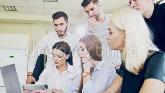 一群年轻的男人和女人正忙着在笔记本电脑上工作而不是等待员工正在做一项任务视频的预览图
