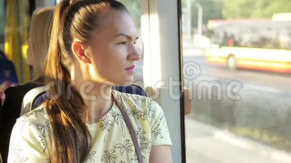从火车窗口望出去的年轻女子女孩想着在火车窗口附近坐着什么视频的预览图