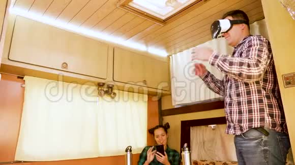在复古露营车内体验虚拟现实护目镜的男朋友视频的预览图