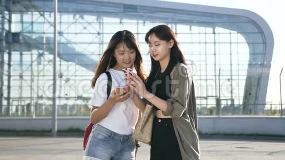 穿着休闲服装手机站在机场附近的亚洲年轻女孩迷人视频的预览图