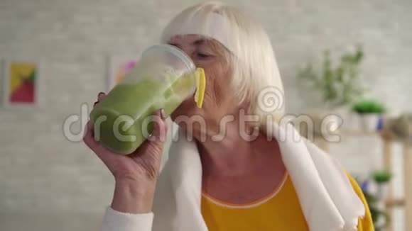 积极健身奶奶在搅拌机里喝绿冰沙运动饮食视频的预览图
