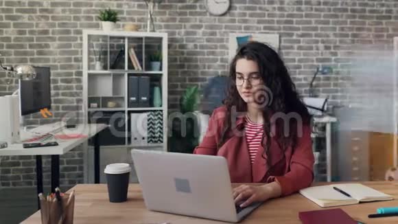 忙碌的女企业家在阁楼风格的办公室里用笔记本电脑工作的时间视频的预览图