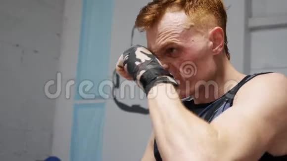 拳击手在体操训练前按摩脸部拳击手在搏击俱乐部的拳击台上做热身运动视频的预览图