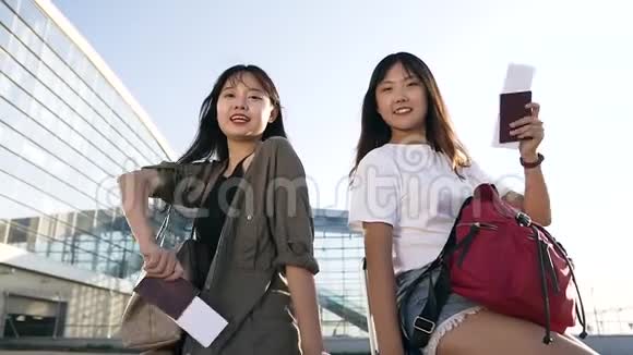 在联合旅行前带着护照和机票在镜头上摆着迷人的快乐亚洲女孩的正面景色视频的预览图