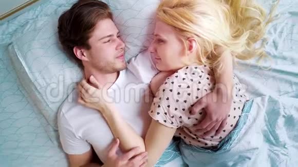 在清晨的床上在浪漫的一对情侣的上方视频的预览图