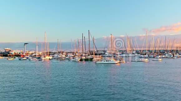 海上的码头豪华游艇停泊在海湾日落或黎明太阳光芒美丽地照亮了船视频的预览图