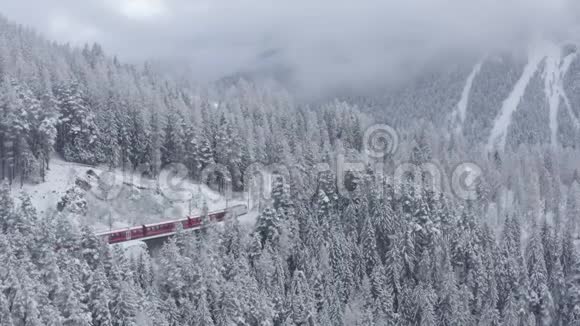 冬季红色冰川快车著名列车的空中视频列车在树林中移动这是一座地标性建筑视频的预览图