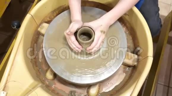 这孩子在陶工的轮子上做了一个粘土花瓶视频的预览图