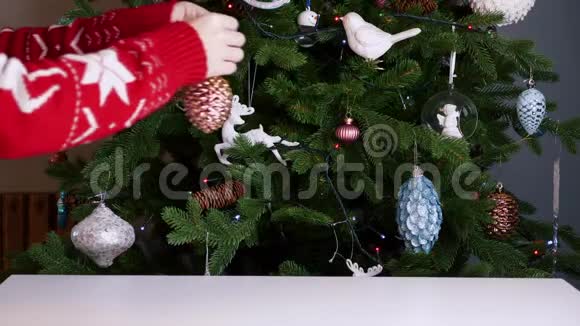 女人们穿着红色的圣诞毛衣把玩具挂在圣诞树上视频的预览图