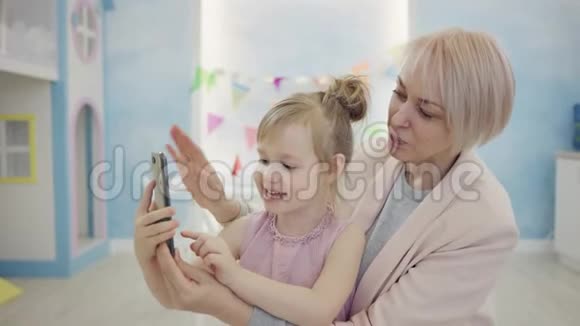 小女孩和她的母亲正在使用智能手机进行视频游戏视频的预览图