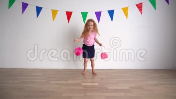 有创意的小女孩假装啦啦队员拿着粉红色的柚子纸球视频的预览图