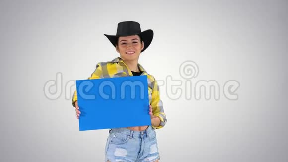 微笑漂亮的女牛仔拿着空板在渐变背景下跳舞视频的预览图