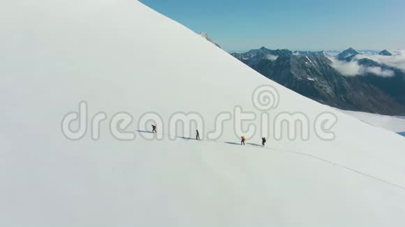 登山者正在雪山上作为骑自行车的队伍前进鸟瞰图视频的预览图