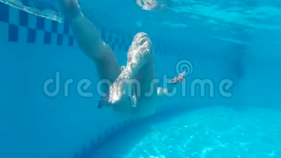 戴眼镜和泳装的少女在水下游泳池游泳穿着蓝色的水下护目镜的女孩视频的预览图