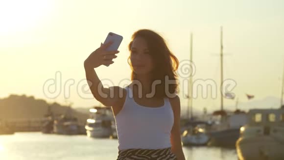 幸福的女人在晚上的港口拍照旅行女郎自拍视频的预览图