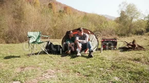 漂亮的年轻夫妇在露营帐篷前聊天视频的预览图