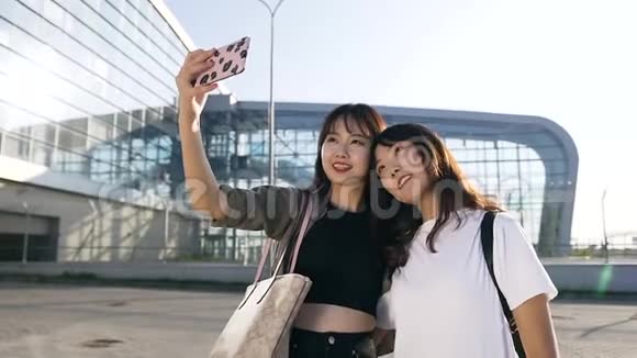 活泼可爱的亚洲女伴在机场背景上自拍的慢动作视频的预览图