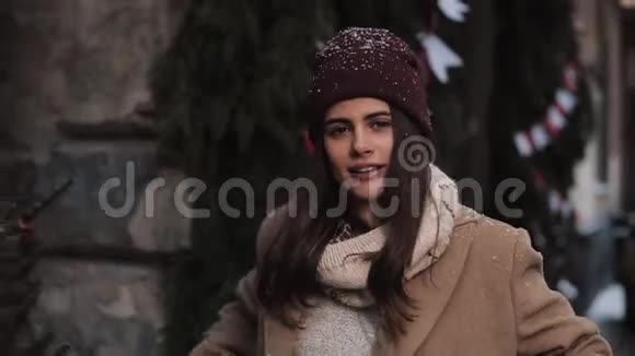 年轻漂亮的白种人女孩穿着冬天的衣服把帽子放直微笑着看着镜头走进来视频的预览图