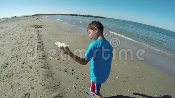 在海岸线上玩飞机的男孩视频的预览图