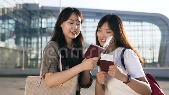 在飞机起飞前年轻的亚洲女性在机场背景上看着自己的机票非常兴奋视频的预览图