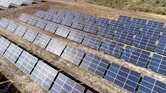 一个空中向后移动的镜头在太阳能电池板上躺在田野上视频的预览图