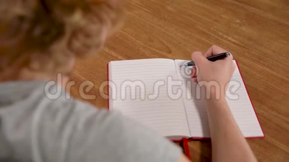 年轻女子用墨水笔在白色笔记本上写文字视频的预览图