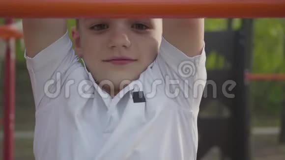 小帅哥攀爬小朋友操场上的台阶特写积极的生活方式无忧无虑的童年可爱视频的预览图