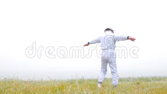 一个穿着宇航员服装的男孩正试图在他的怀里飞向天空视频的预览图