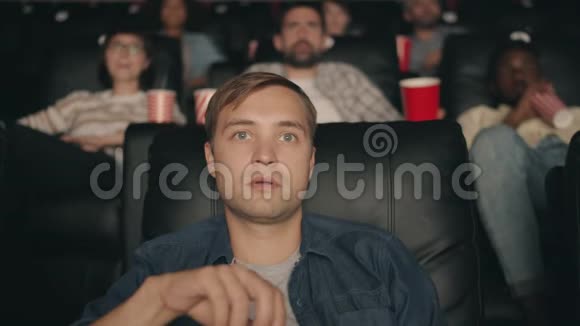 震惊的学生在电影院看电影张嘴吃爆米花微笑视频的预览图