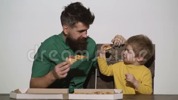 男人和孩子一起吃美味的披萨可爱的白种人小男孩在吃比萨饼时被白种人隔离视频的预览图