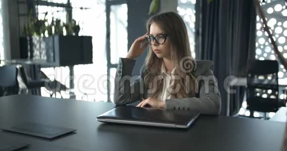 年轻的女商人打开笔记本电脑视频的预览图