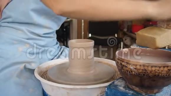 女陶工在陶工的车轮上雕刻一罐粘土视频的预览图