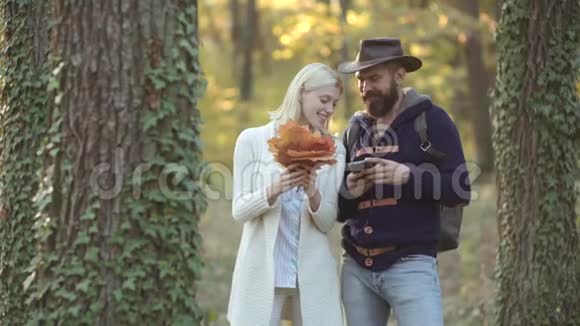 时尚秋季模特在公园摆姿势时尚的秋天肖像女人和男人与黄色枫叶自然视频的预览图