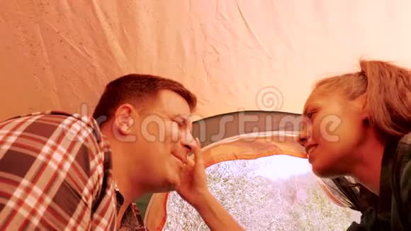 从露营帐篷里看到一对夫妇互相微笑视频的预览图