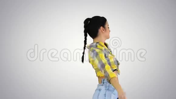 华丽可爱的女孩穿着牛仔裤短裤运动鞋在梯度背景下跳舞视频的预览图