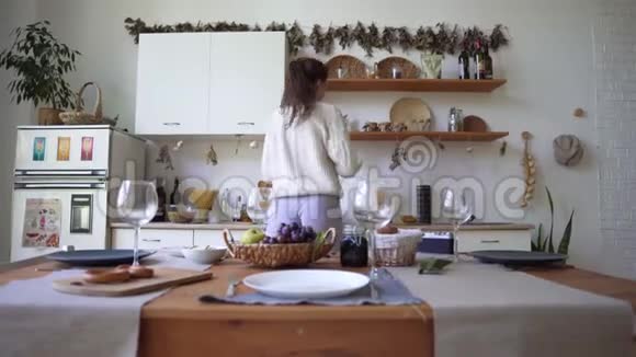 一个年轻的女人正在准备晚餐站在厨房里北欧风格的阁楼公寓采用视频的预览图