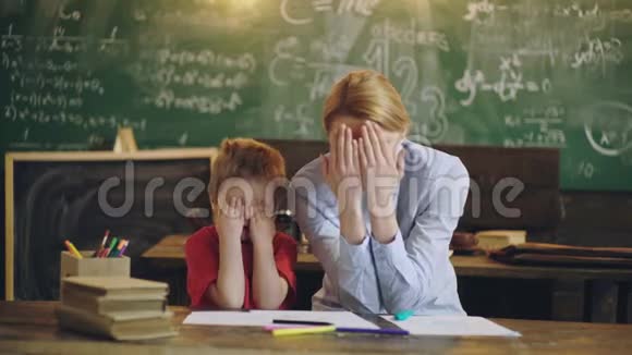 家庭学校父母教孩子私人课程男孩和女人在学校教室里用手掌捂住脸视频的预览图