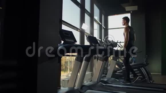 年轻的运动男女在运动健身房的跑步机上锻炼和行走视频的预览图