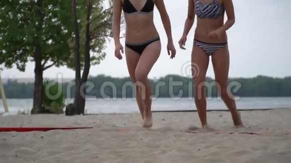 年轻的运动女性在沙滩上奔跑击掌视频的预览图