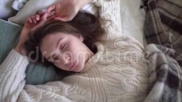 一个穿着白色毛衣舒适舒适的熟睡女孩的俯视图视频的预览图