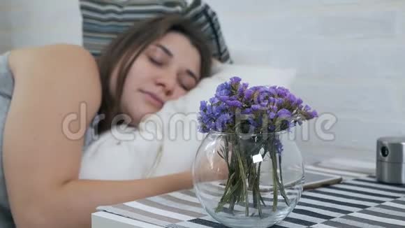 为孕妇准备的花美丽的女人睡在床上怀孕的女孩喜欢站在床边的鲜花视频的预览图