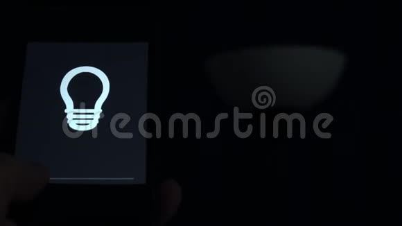 智能家居男人用手机上的应用程序控制灯光视频的预览图