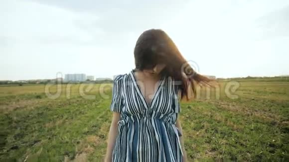 浪漫帅气的黑发女人走在田野上视频的预览图