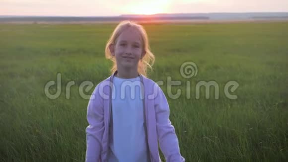 日落时分小女孩正在草地上奔跑童年梦想的概念或前进的愿望视频的预览图
