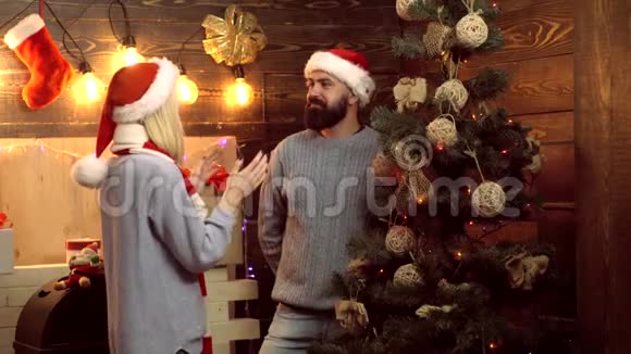 给圣诞礼物的人带着圣诞礼物令人惊讶的漂亮女孩新年有趣的一对圣诞节视频的预览图